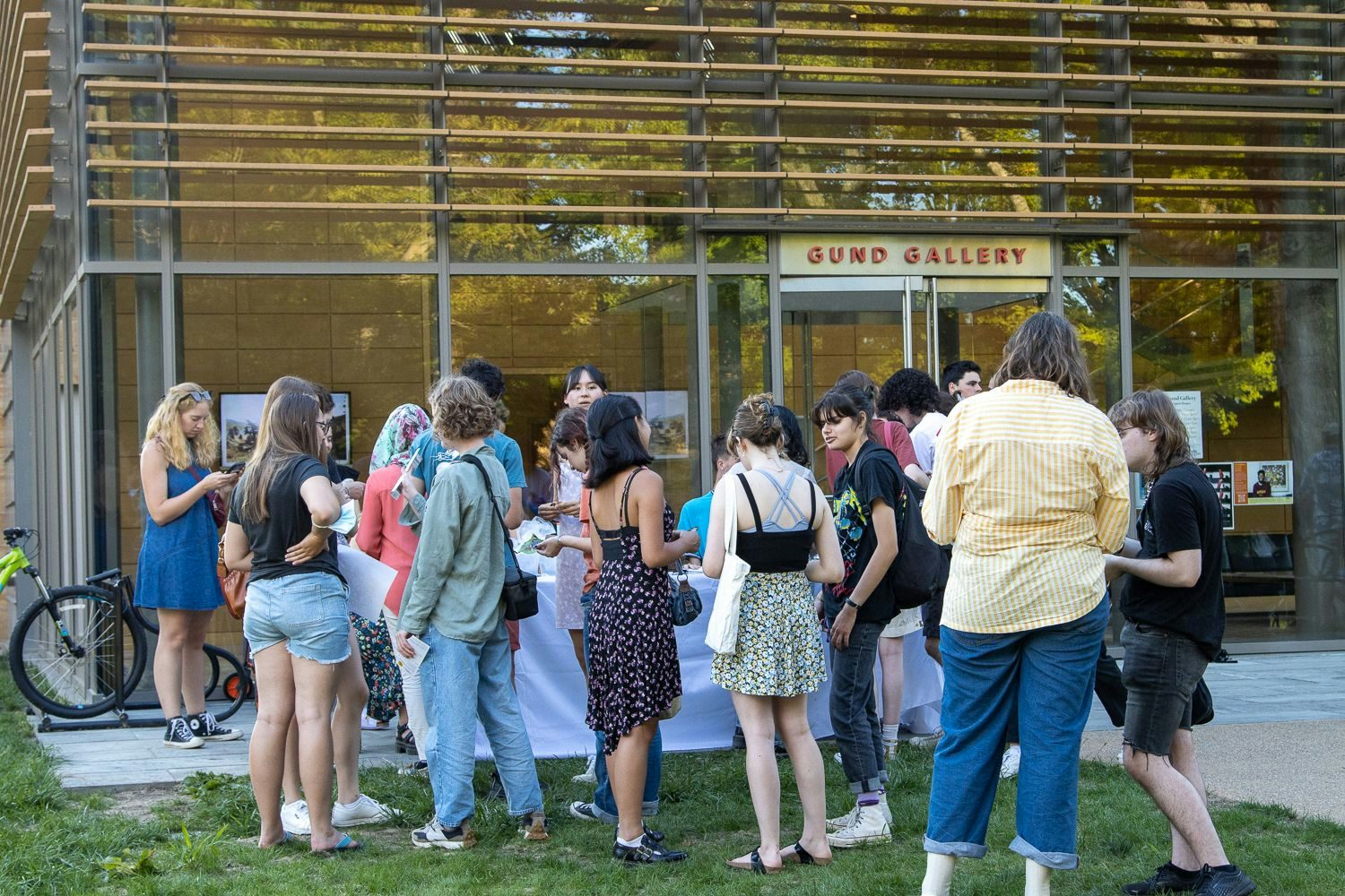 A crowd of students gathers outside the Gund Gallery for the button making table during Community Feast. 