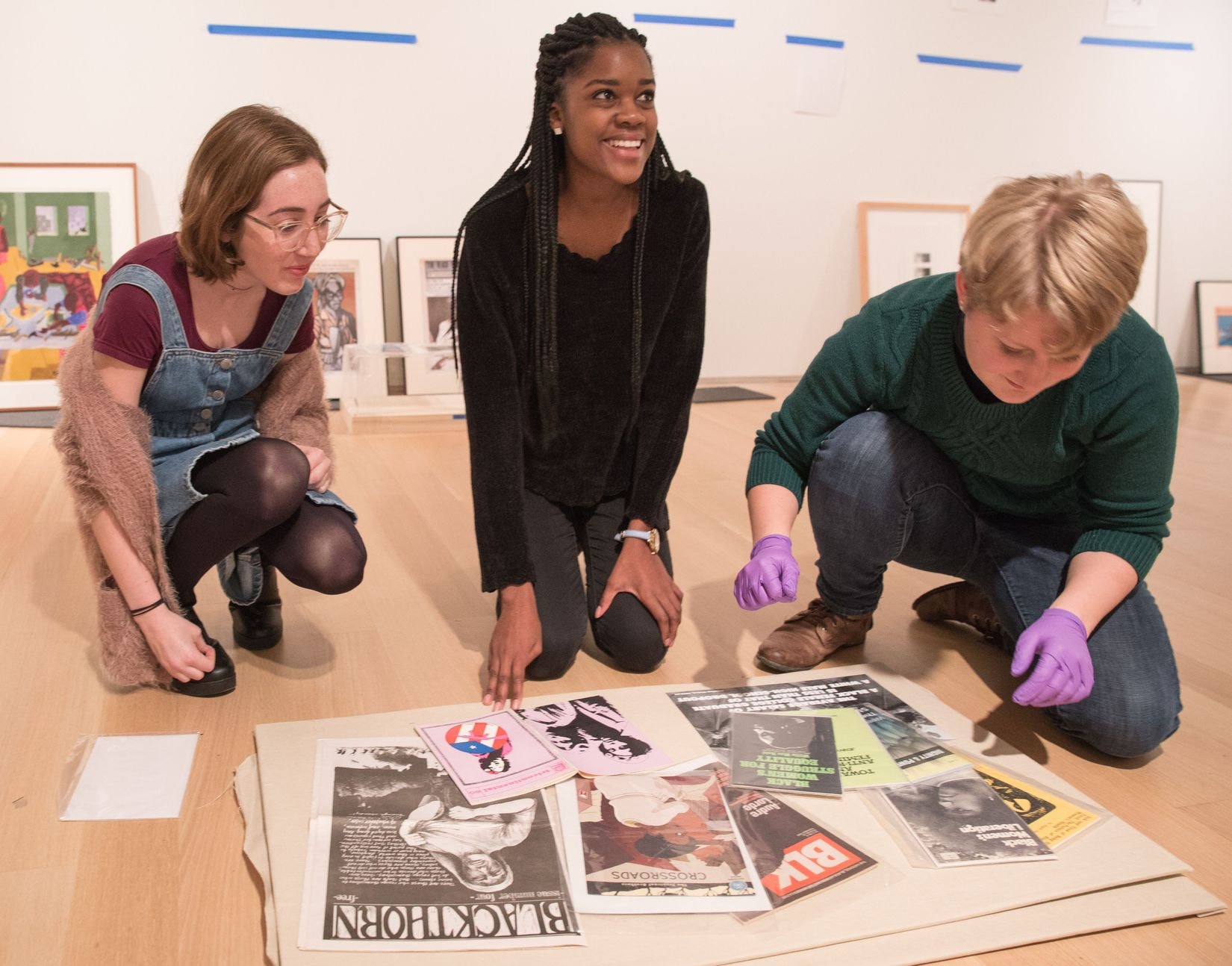 Three Gund Associates work on a project together. They are happy.