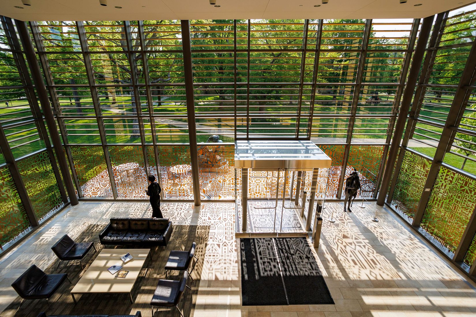 An interior view of the Fischman Lobby of Gund Gallery from above with Caroline Monnet's installation piece on the glass walls.