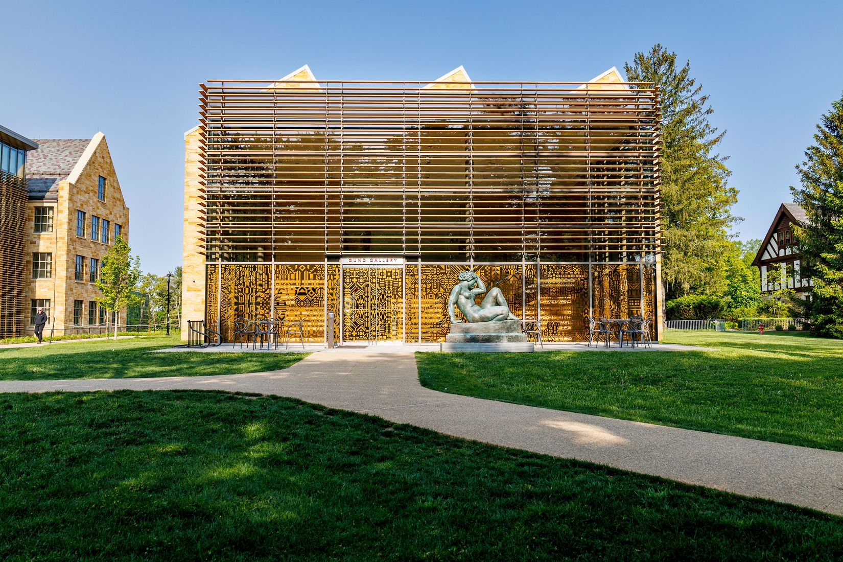 The exterior of the Gund Gallery building during the day with Caroline Monnet's installation on the glass walls of the atrium.
