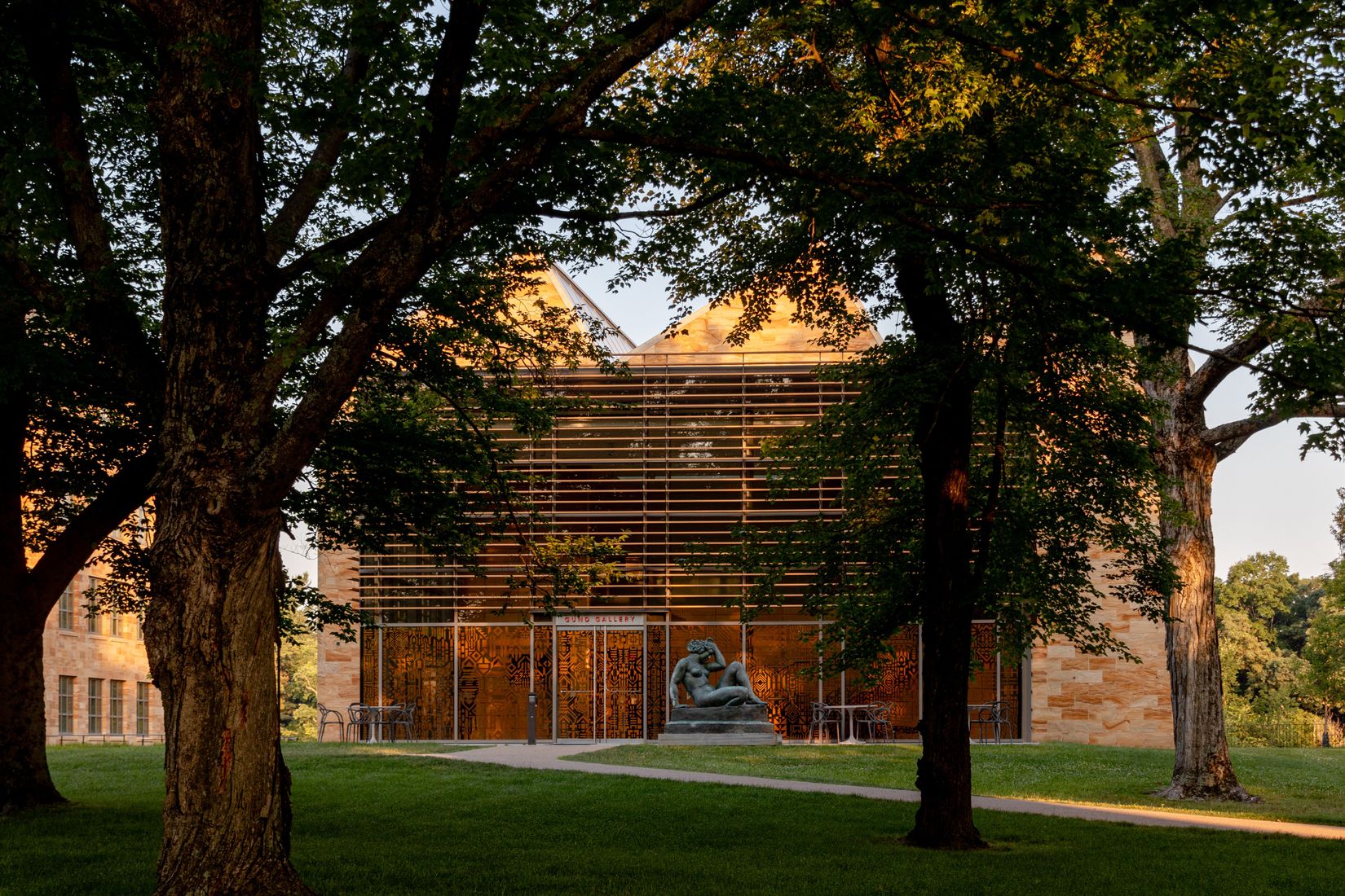 A exterior view of the Gund Gallery building situated in between two trees. 